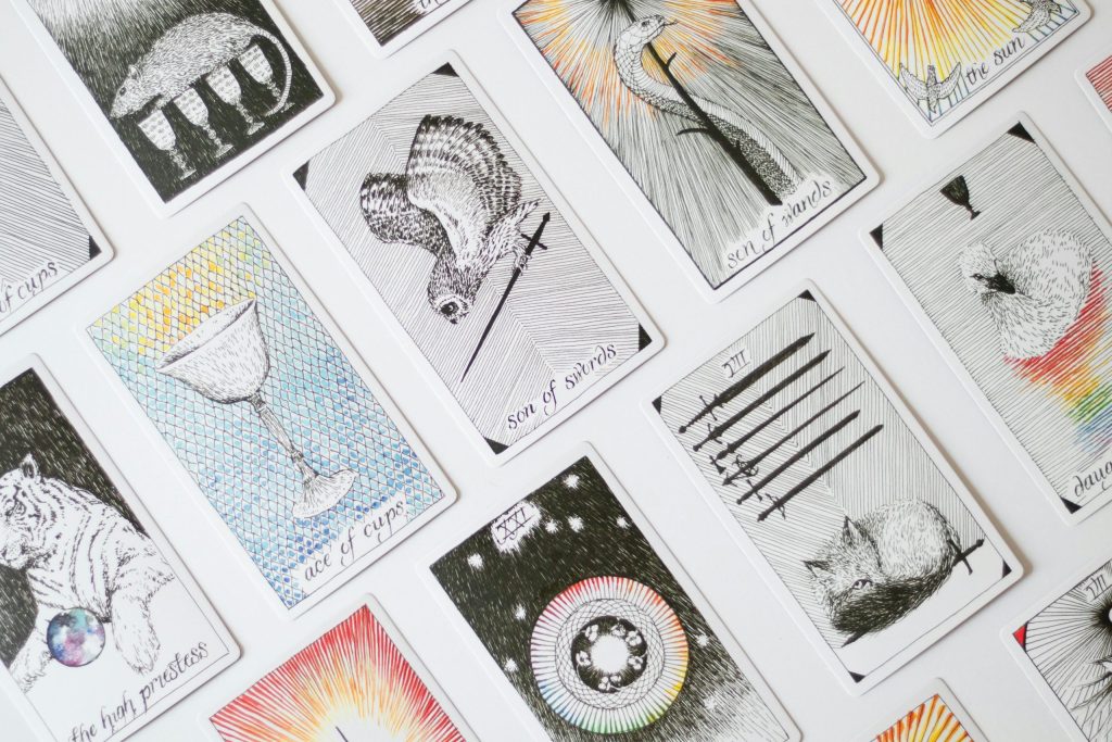 pexels-photo-26891742-26891742 A collection of tarot cards displaying various illustrations, arranged on a white backdrop.