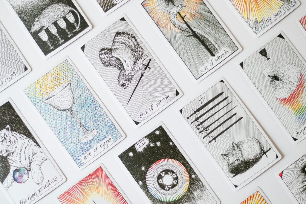 A collection of tarot cards displaying various illustrations, arranged on a white backdrop.